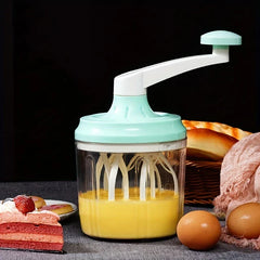 Manual Rotary Hand Whisk Egg Beater - Hand-crank mixing tool holding beaten yellow egg mixture, displayed alongside fresh eggs, sliced cake, and bread on a dark table surface