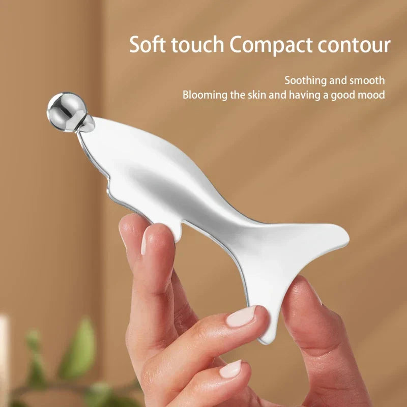 Gua Sha Facial Massager - Hand holding polished silver mermaid wing facial massage tool against warm neutral background