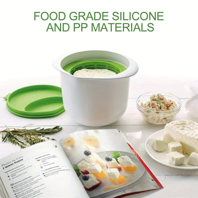 Ricotta Cheese Maker - Open white container with green strainer insert inside, holding a white soft food, lid set to its left with prepared foods nearby