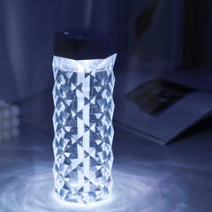 Cool Mist Humidifier - Close-up angled view of illuminated faceted humidifier with black top cap, sitting on a dark desk surface