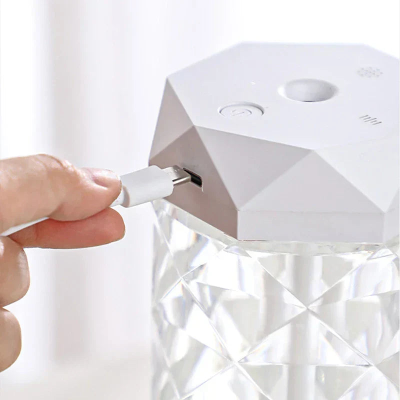 Cool Mist Humidifier - Hand inserting a white USB-C cable into a white faceted humidifier with a clear faceted water reservoir