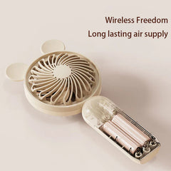 Mini Manual Handheld Squeeze Fan - Off-white handheld fan with its handle opened showing two batteries inside, text reading Wireless Freedom Long lasting air supply to the upper right