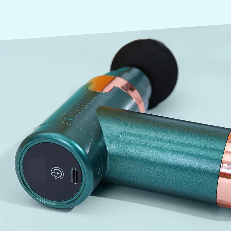 Pistolet de massage par percussion - Pistolet de massage turquoise et or rose posé horizontalement, montrant son panneau de commande, son bouton d’alimentation et son port USB-C