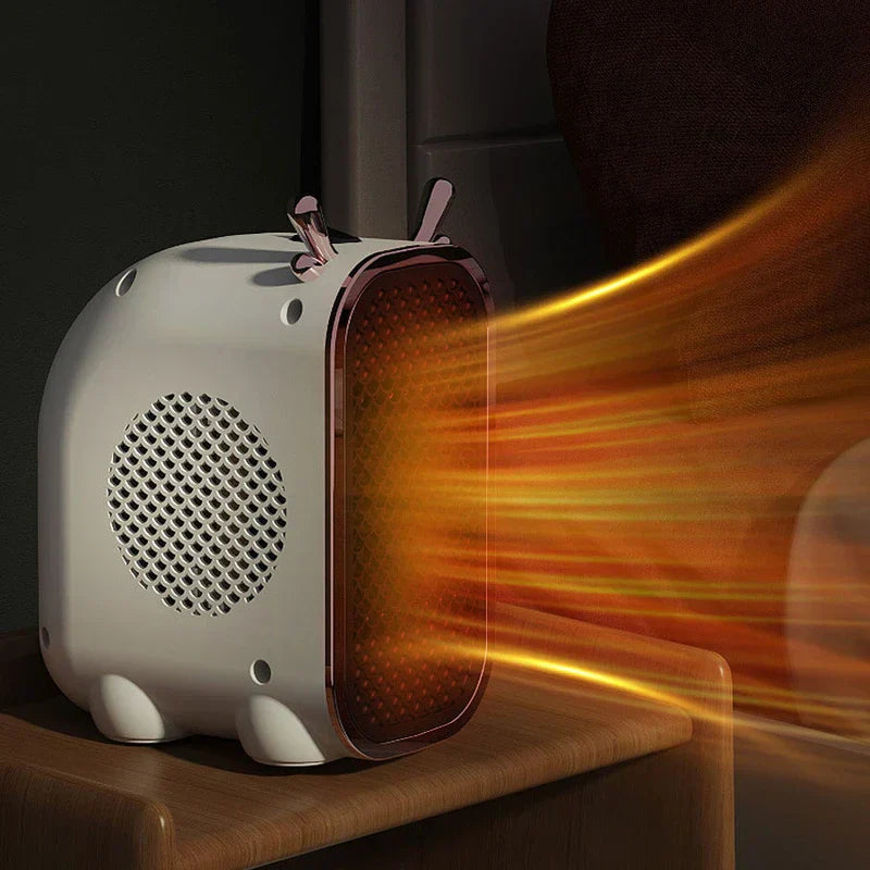 Mini Space Heater - White compact desktop heater sitting on a dark wood shelf, blowing warm orange air out its rose gold-trimmed front grille, side intake grille visible.