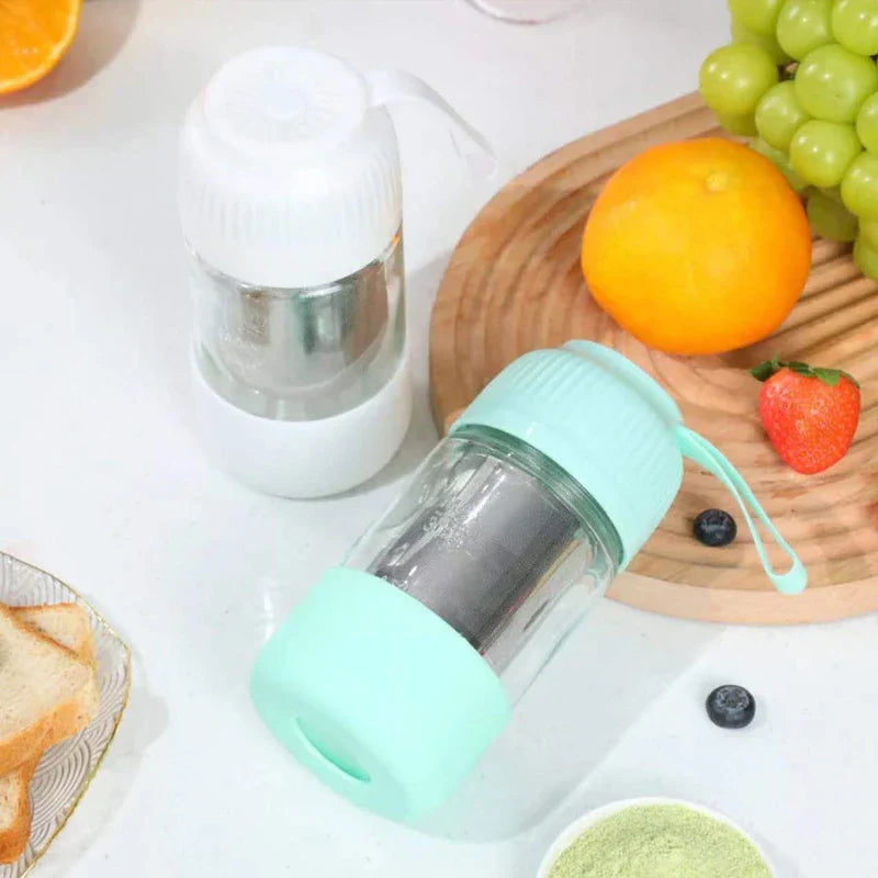 Mini Juicer Blender - Two portable blenders (white and mint green) sit on a countertop near fruit, bread, and a small bowl of powder