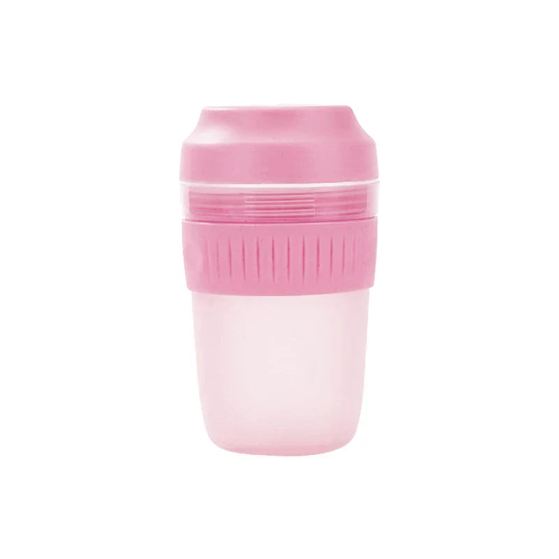 Portable Juicer Blender - Compact pink and translucent plastic lidded cup with ribbed grip band and frosted lower portion.