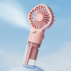 Usb Fan - Pink handheld misting fan emitting fine water mist against a light blue sky background