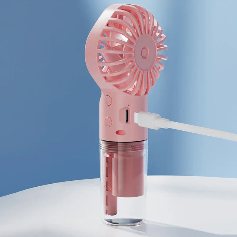 Usb Fan - Side view of pink handheld fan with a white charging cable plugged into its USB-C port.