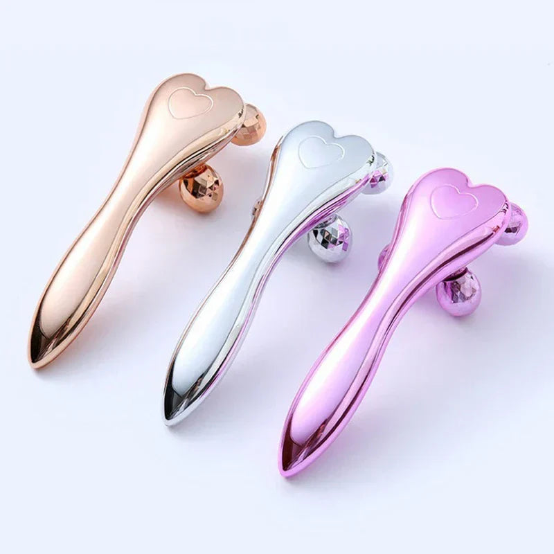Face Slimming Massager - Three heart-shaped facial rollers in rose gold, silver, and pink finishes arranged side by side on a light background