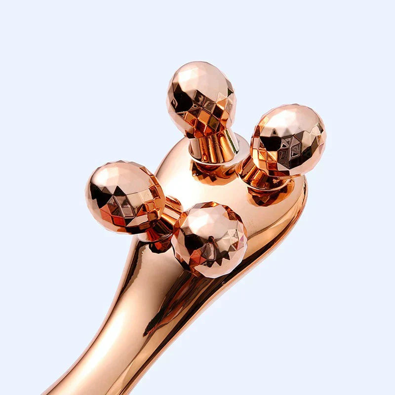 Face Slimming Massager - Close-up view of the four faceted roller ends of a rose gold facial massager