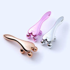 Face Slimming Massager - Three heart-shaped facial roller tools in rose gold, pink, silver finishes, laid flat