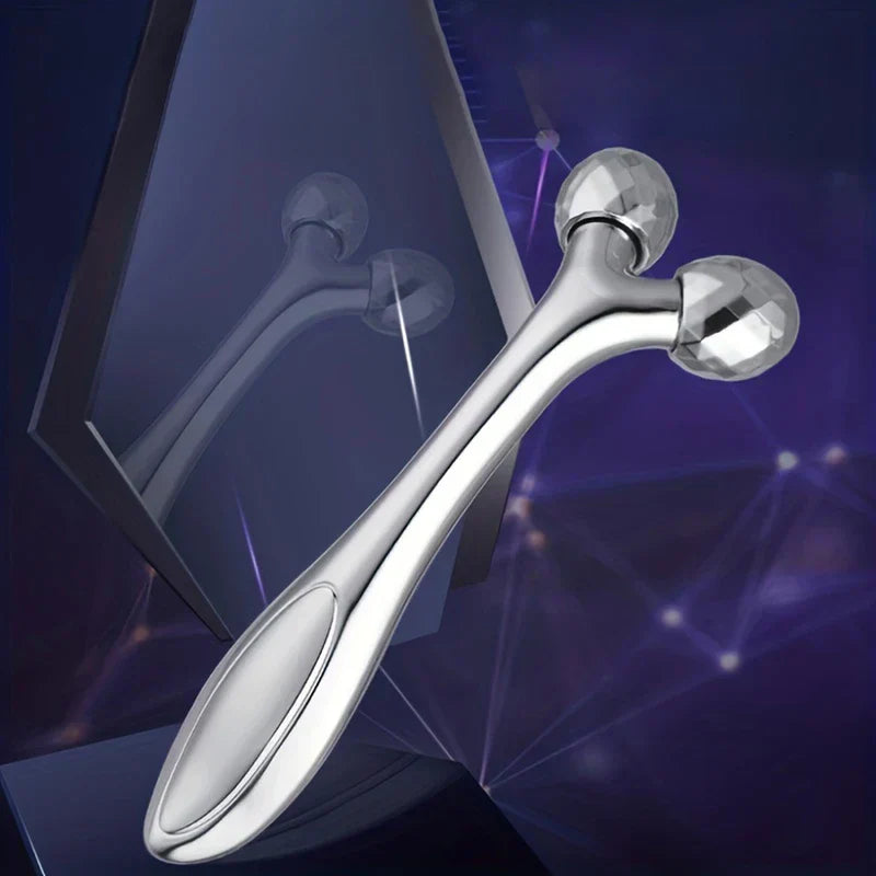 Face Slimmer - Silver dual-ball facial roller with faceted roller heads, displayed against a dark purple background with a reflective surface behind it.