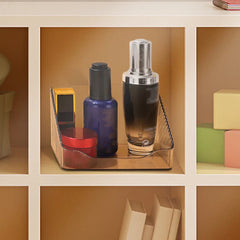 Mirrored Cabinet Organizer Bin - Amber-tinted slanted storage organizer holding skincare bottles inside a light-colored cubby shelf.