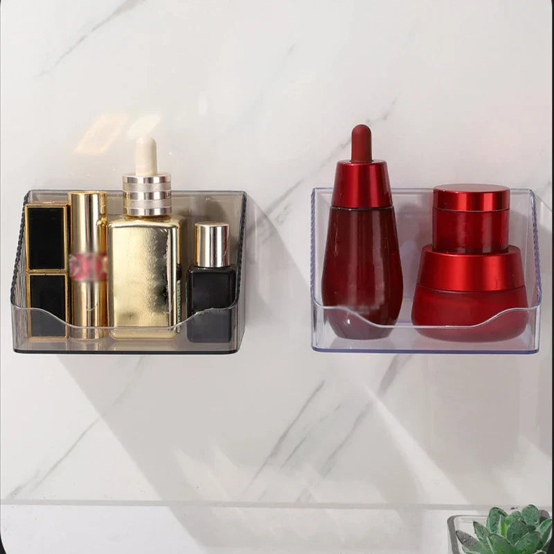 Mirrored Cabinet Organizer Bin - Two clear plastic wall-mounted storage organizers holding cosmetics, mounted on a white marble-patterned wall