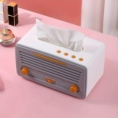 Tissue Box Cover - White and gray retro radio-style tissue box holding a partially pulled-out tissue, placed on a pink surface