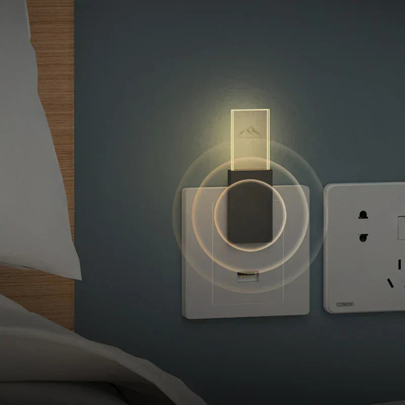 ضوء ليلي طارد البعوض - ضوء ليلي صغير يعمل بمنفذ USB موصول بمقبس طاقة جداري، يضيء بتوهج دافئ، ومثبت على جدار أزرق داكن بجوار وسادة سرير