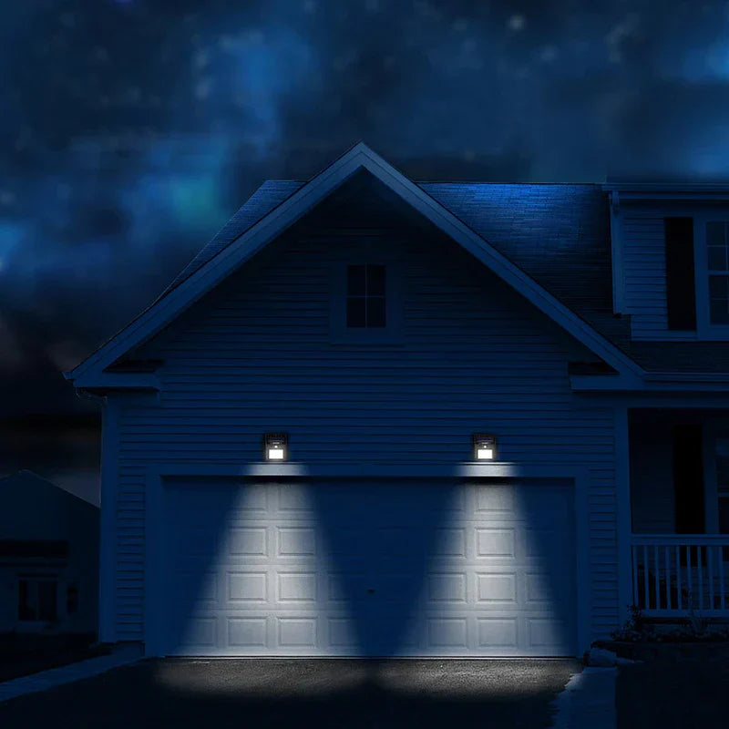 Motion Sensor Light - Two motion sensor lights mounted on a house garage wall, casting light on the garage door at night