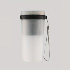 Frosted vertical-ribbed portable juicer blender with a black lid ring and gray wrist lanyard, on a light gray background