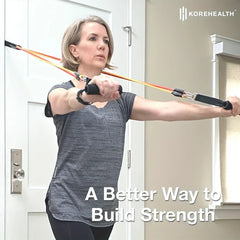 Resistance Band Set - Woman with short gray hair uses resistance bands anchored to a door while performing a chest press exercise.