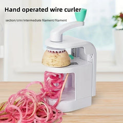 Vegetable Spiralizer Slicer - Hand-crank gadget processing a root vegetable to produce curly vegetable spirals on a wood countertop