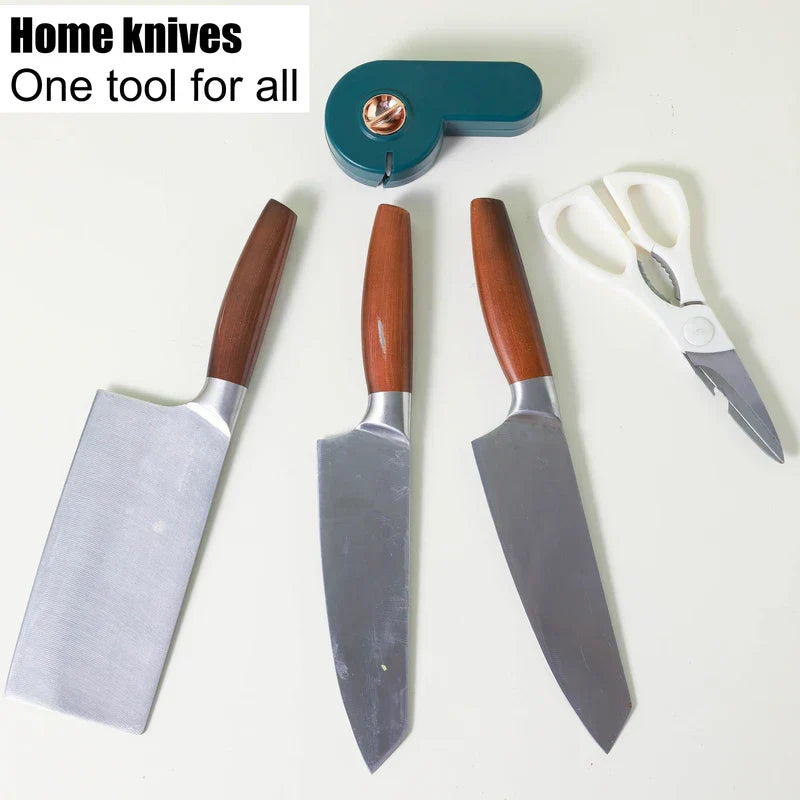 Manual Knife Sharpener - A home knife set with three wooden-handled knives, white-handled kitchen scissors, and a teal handheld sharpener laid on a white surface