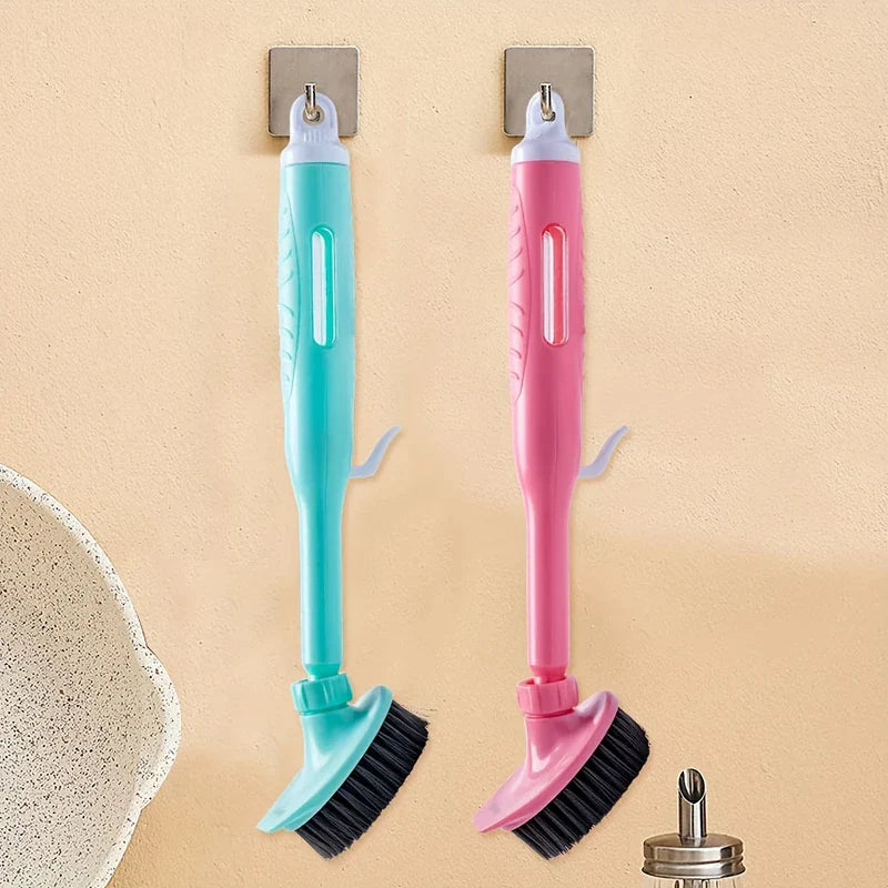 Kitchen Cleaning Brush - Two long-handled kitchen brushes (one turquoise, one pink) with black bristles hang from adhesive wall hooks.