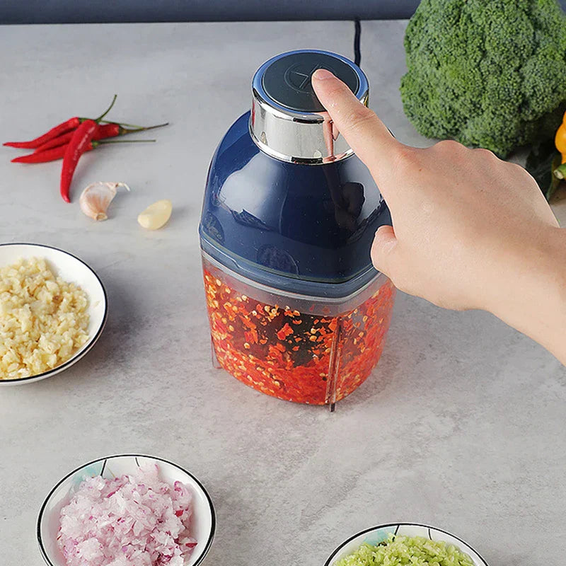 Smoothie Maker - A hand pressing the top of a blue and transparent electric chopper holding chopped chili, with bowls of prepped ingredients around it.