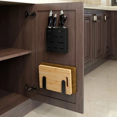 Pot Lid Holder - Inside a wooden cabinet door: upper black knife block holding several knives, lower black brackets holding two stacked cutting boards