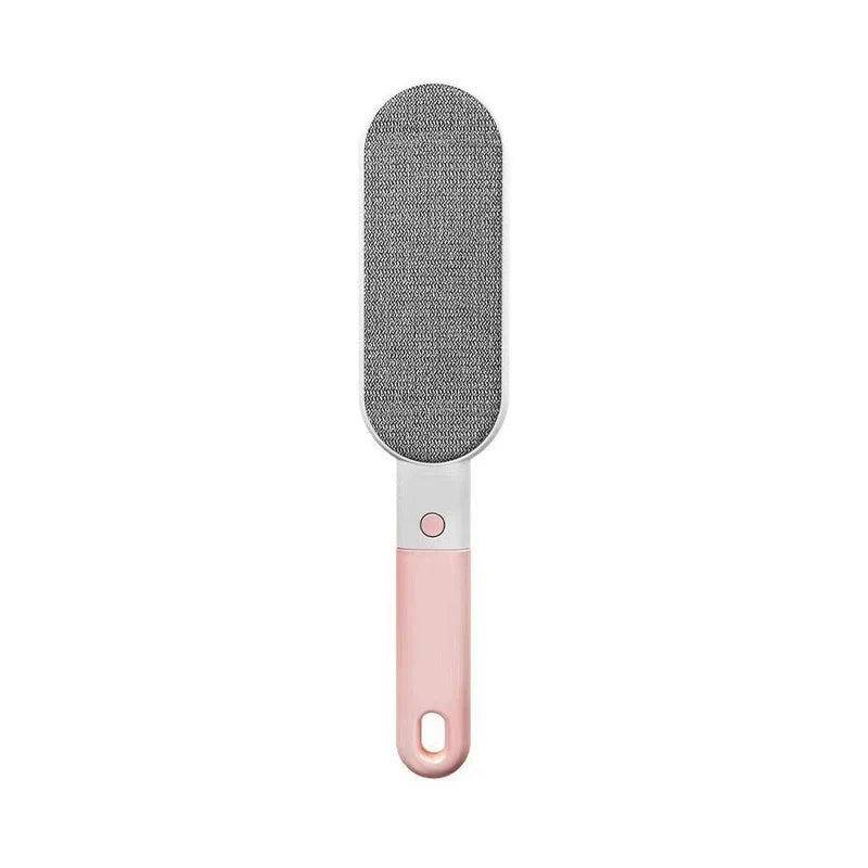 A multifunctional cleaning brush with pink handle and gray lint removal pad rests against a plain white background