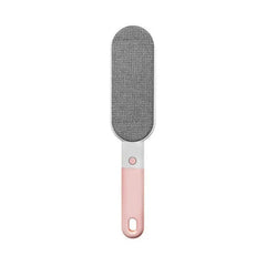 A multifunctional cleaning brush with pink handle and gray lint removal pad rests against a plain white background