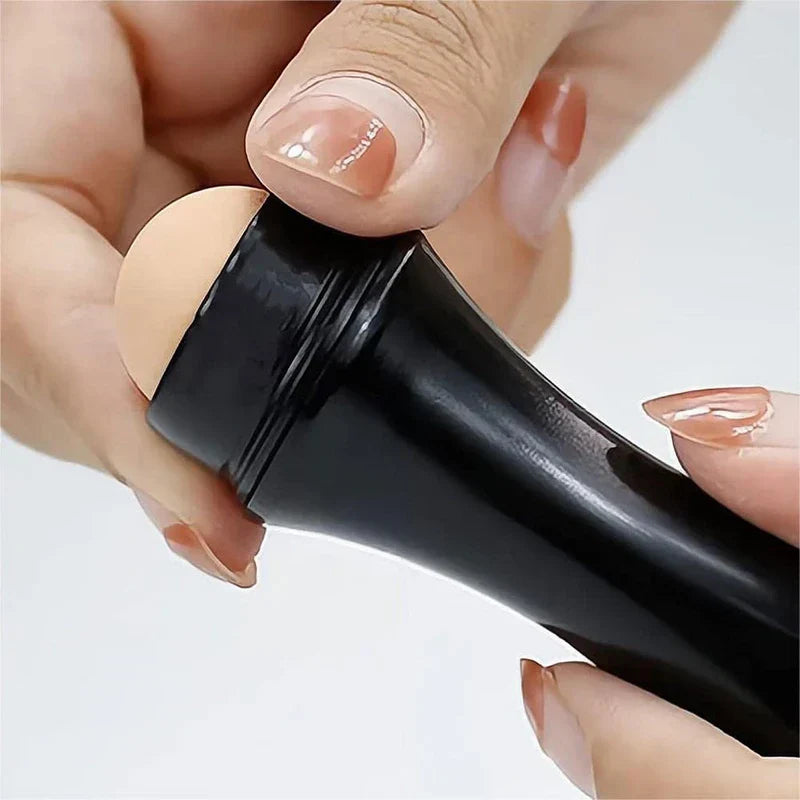 Facial Extraction Tool - Close-up of hands with manicured nails twisting the head of a black roller cosmetic tool
