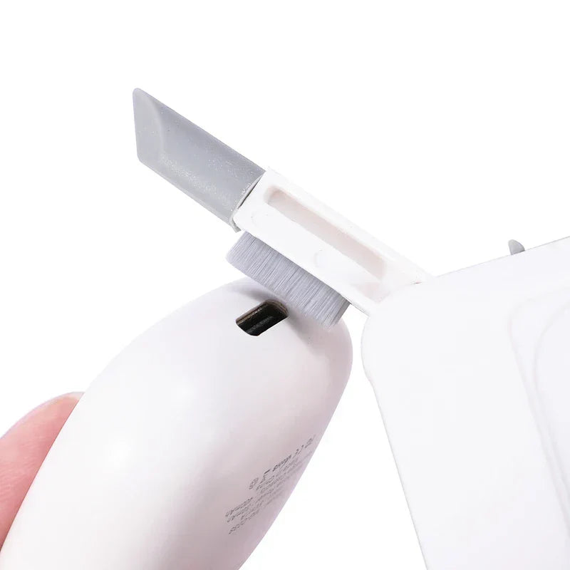Car Cleaning Brush Kit - Cleaning tool with extended narrow plastic tip and brush, cleaning the port on a white electronic device.