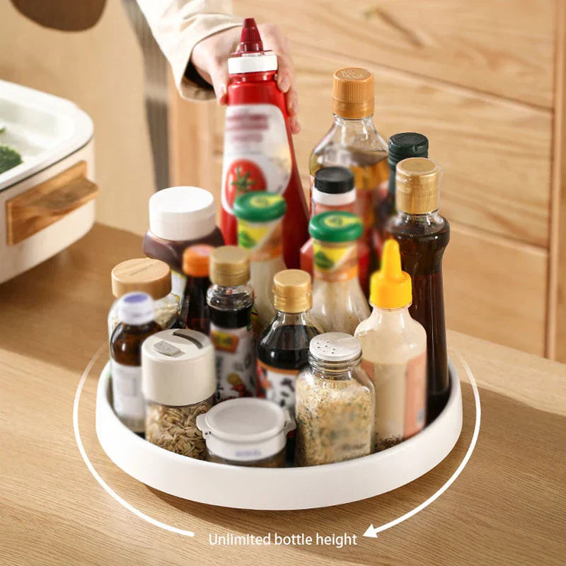 Rotating Storage Turntable Tray Organizer - Hand placing a red squeeze bottle onto a white rotating tray holding various condiment bottles