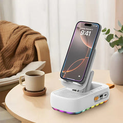 A white multifunctional stand holder mount holds a smartphone on a round table beside a coffee cup, with a chair and plant in the background.