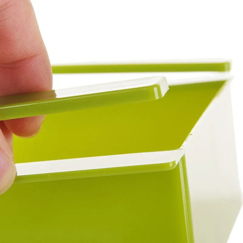 Storage Box Organizer - Close-up of a finger lifting the retractable rail tab on a green plastic storage box.