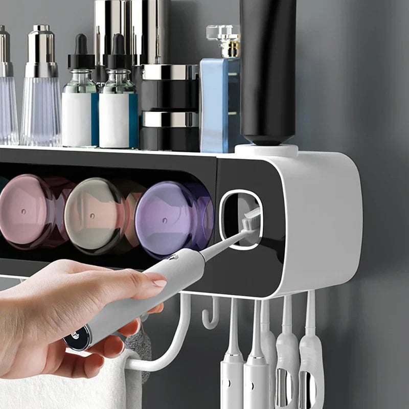 Toothbrush Holder - Wall-mounted organizer mounted on a dark wall, with a hand inserting an electric toothbrush into its automatic toothpaste dispenser, holding oral care items above.