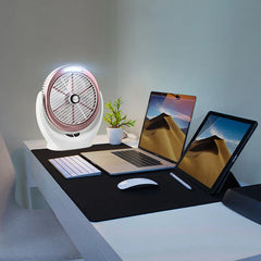 Desk Fan - Rose-gold trimmed desktop fan with its top light turned on, placed on a desk alongside a laptop, tablet, keyboard and small plant.