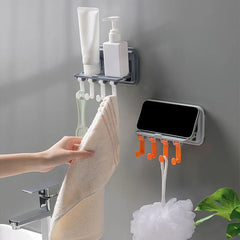 Utility Hook Hanger - Two wall-mounted holders: a gray shelf with white hooks holding toiletries and a towel, plus a gray phone holder with orange hooks holding a bath loofah, beside a sink faucet