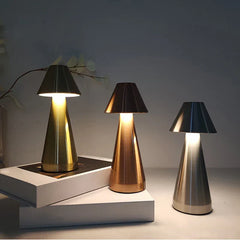 Desk Light - Three illuminated metallic mushroom lamps in gold, copper, and silver finishes arranged on stacked white display risers