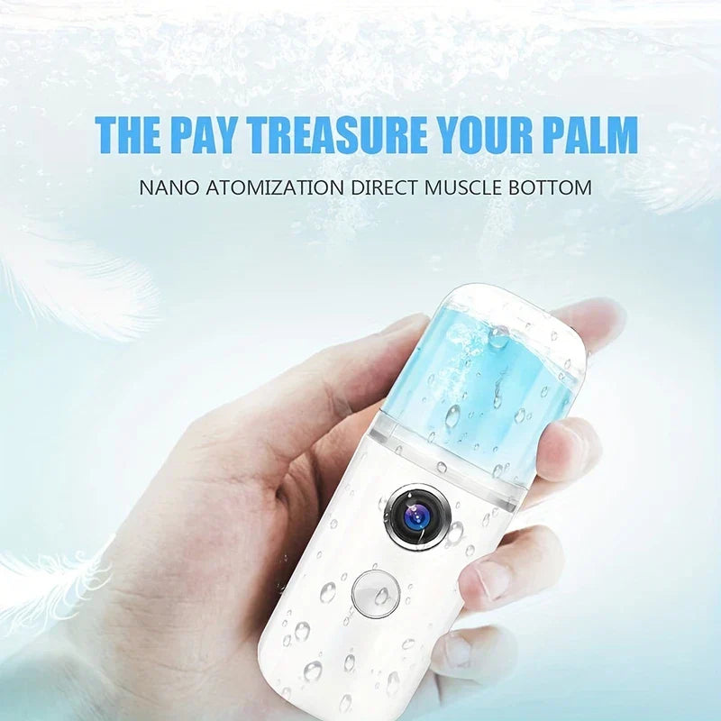 Nano Facial Mist Sprayer - Hand holding a small white and clear handheld mist spray device, against a light blue water-themed background