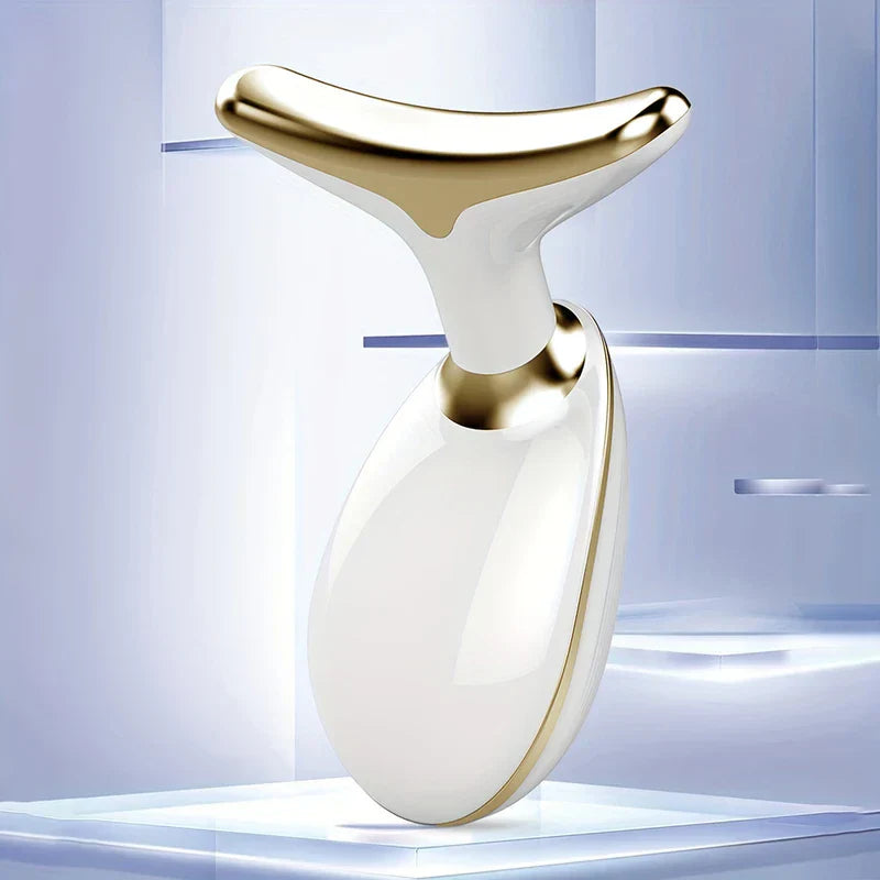 Neck Firming Massager With Heat Vibration Therapy - White and gold skincare device resting on a clear acrylic display surface