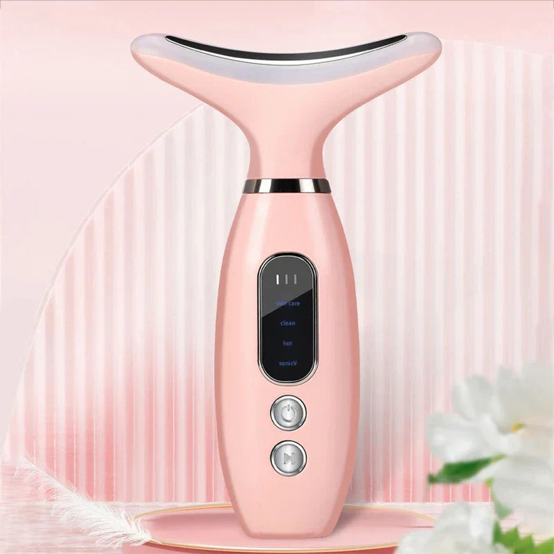 Dispositivo reafirmante de piel para cuello: dispositivo portátil de cuidado de la piel para cuello y rostro rosa, de pie sobre una plataforma rosa con adornos florales