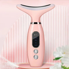 Dispositivo reafirmante de piel para cuello: dispositivo portátil de cuidado de la piel para cuello y rostro rosa, de pie sobre una plataforma rosa con adornos florales