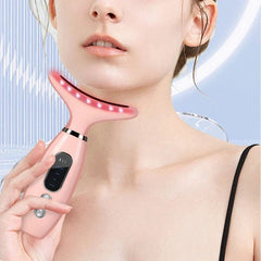Dispositivo reafirmante de piel para cuello: masajeador facial y de cuello rosa en uso en la zona del mentón, con luces rojas activadas