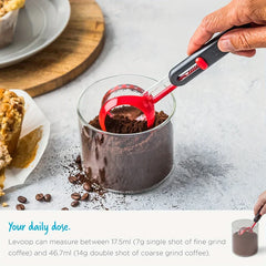 Cucharas medidoras: cuchara medidora ajustable insertada en un frasco de vidrio con café molido, con texto de medición de porción debajo.