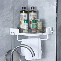 Wall mounted corner kitchen shelf holding spice bottles, with towel bar and utensil hook above sink