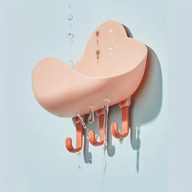 Cloud Wall Hooks - Pink cloud wall soap holder mounted on a wall, water dripping from its drainage edge