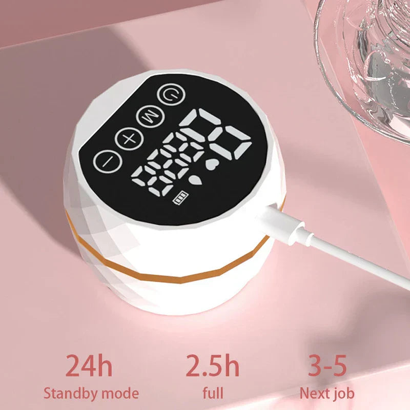Kit del sistema de extracción de leche materna: unidad de control del extractor eléctrico blanco con facetas de diamante, pantalla digital, cuatro botones laterales, cable de carga enchufado y texto sobre modo de espera, tiempo de carga y sesiones debajo, sobre superficie rosa claro