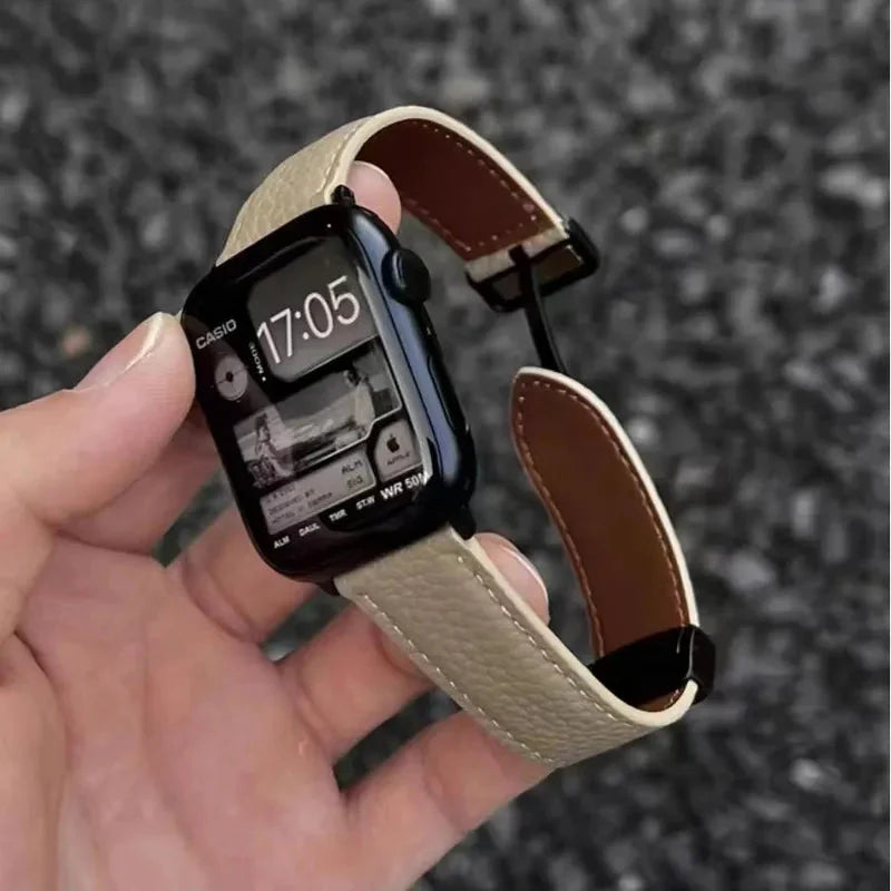 Apple Watch Band - Hand holds a smartwatch with light beige pebbled leather band, watch face shows Casio branding and 17:05 time