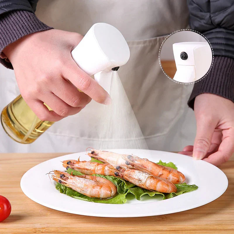 Oil Sprayer - Hand pressing the spray trigger to release a fine mist over a plate of cooked shrimp on lettuce
